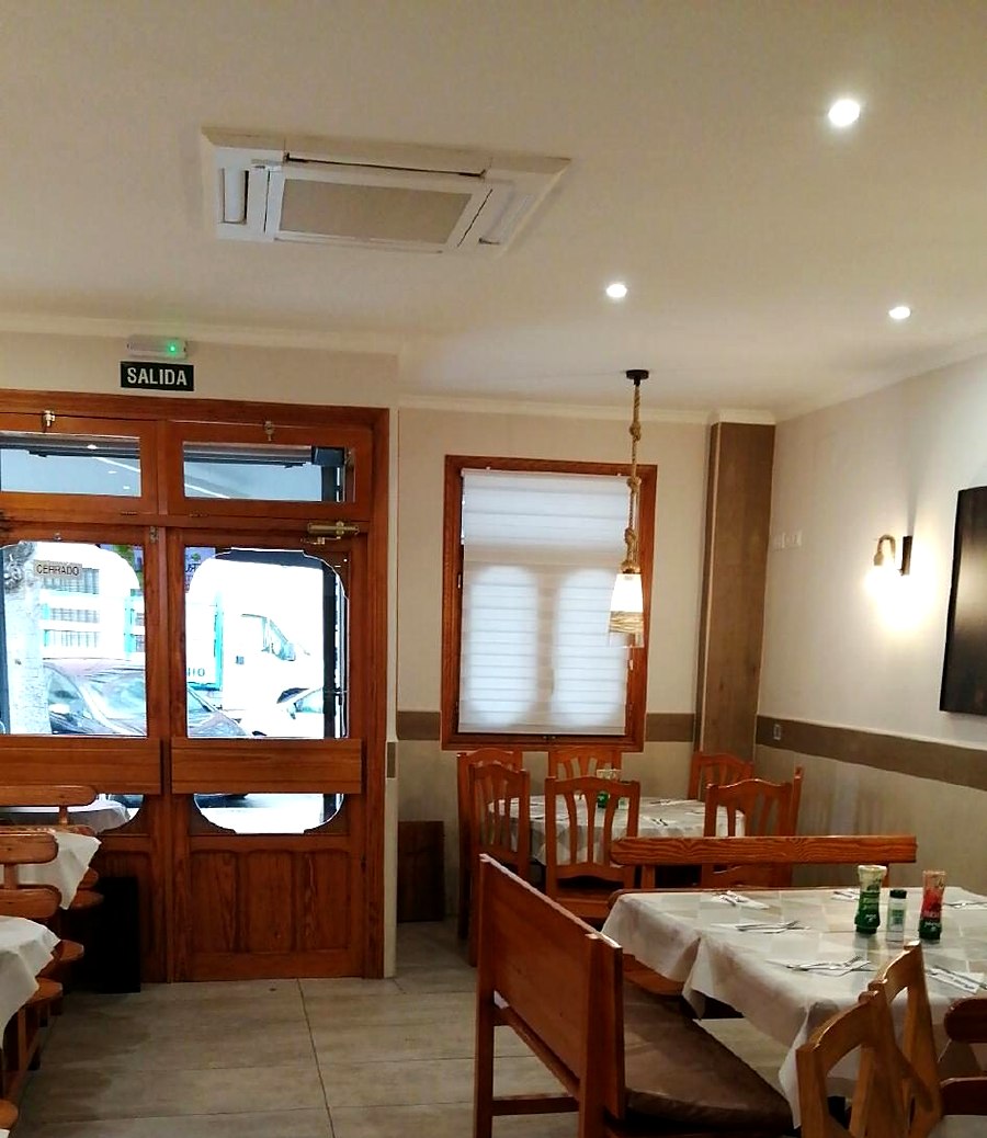Comedor de Manbys: mesas y sillas de madera, sillas junto a las ventanas